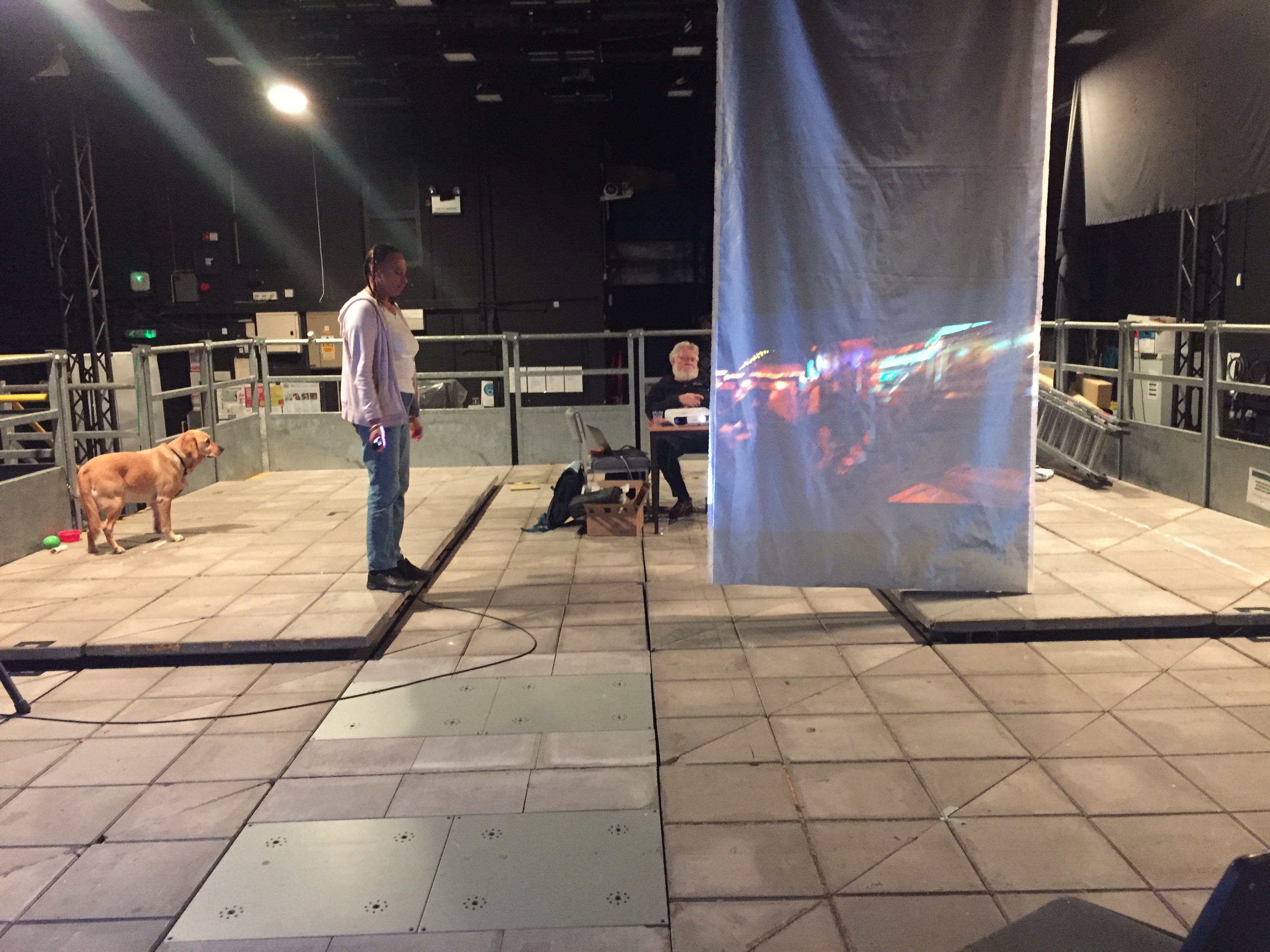 Maria standing on a raised pavement configuration with projector aimed towards her