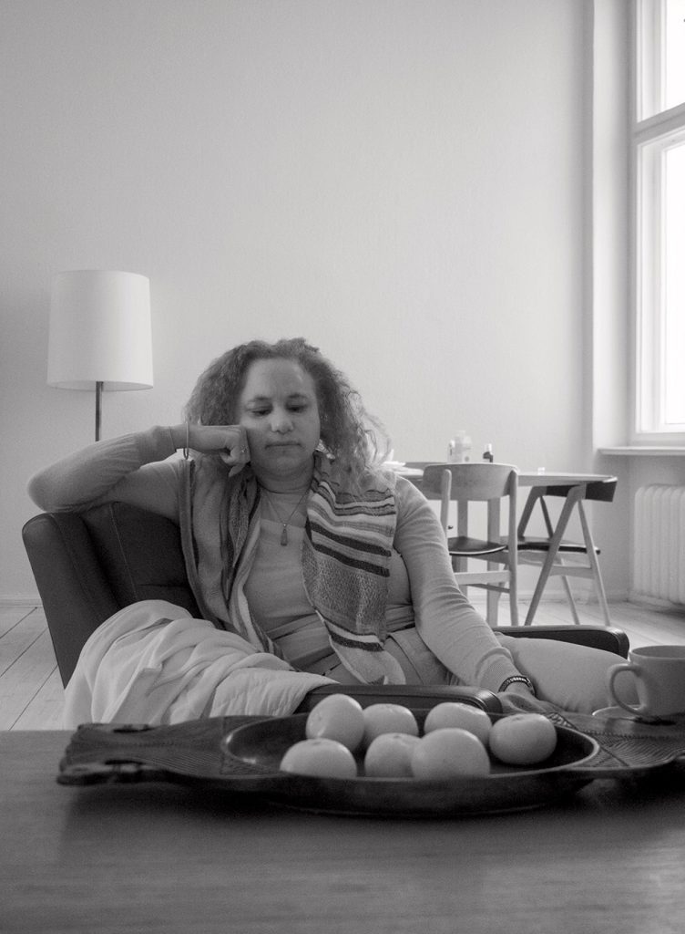 Black and white picture of Maria sitting in a chair, head resting on a hand in contemplation