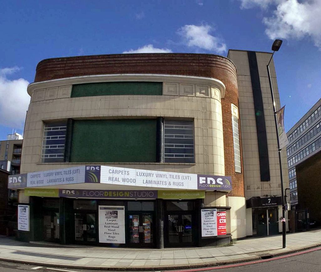 A Stretham ex-cinema re-branded as a carpet store  - sunshine is
illuminating the cinemas former marquee, on which now reads in large movie
advertising letters, "CARPETS  LUXURY VINYL TILES   REAL WOOD   LAMINATES &
RUGS