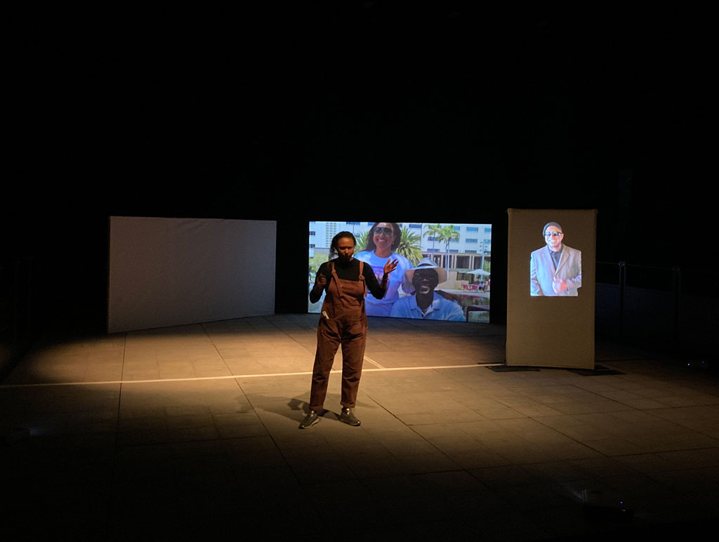 Maria  on stage and Lynn on his own screen down stage with an image of Lynn and Maria together on a bigger screen behind on the right