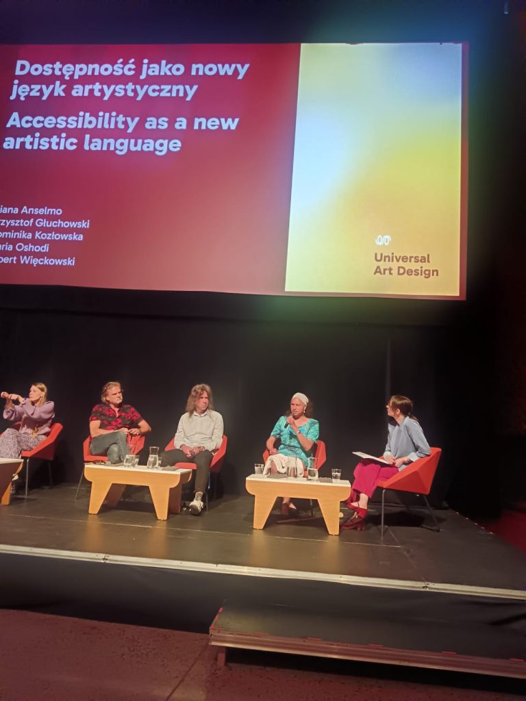Maria presents on a panel with 5 other people and the title Accessibility as a new artistic language, on a screen behind her.